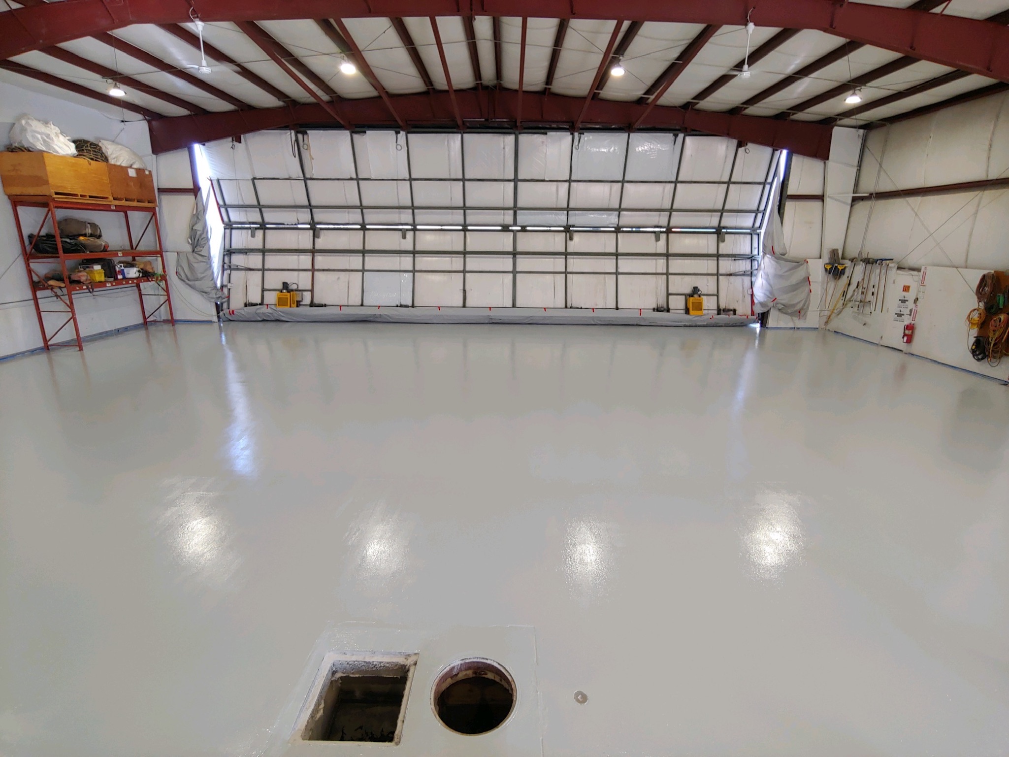 Aircraft hangar with solid white professional floor coating by Sparks Coatings