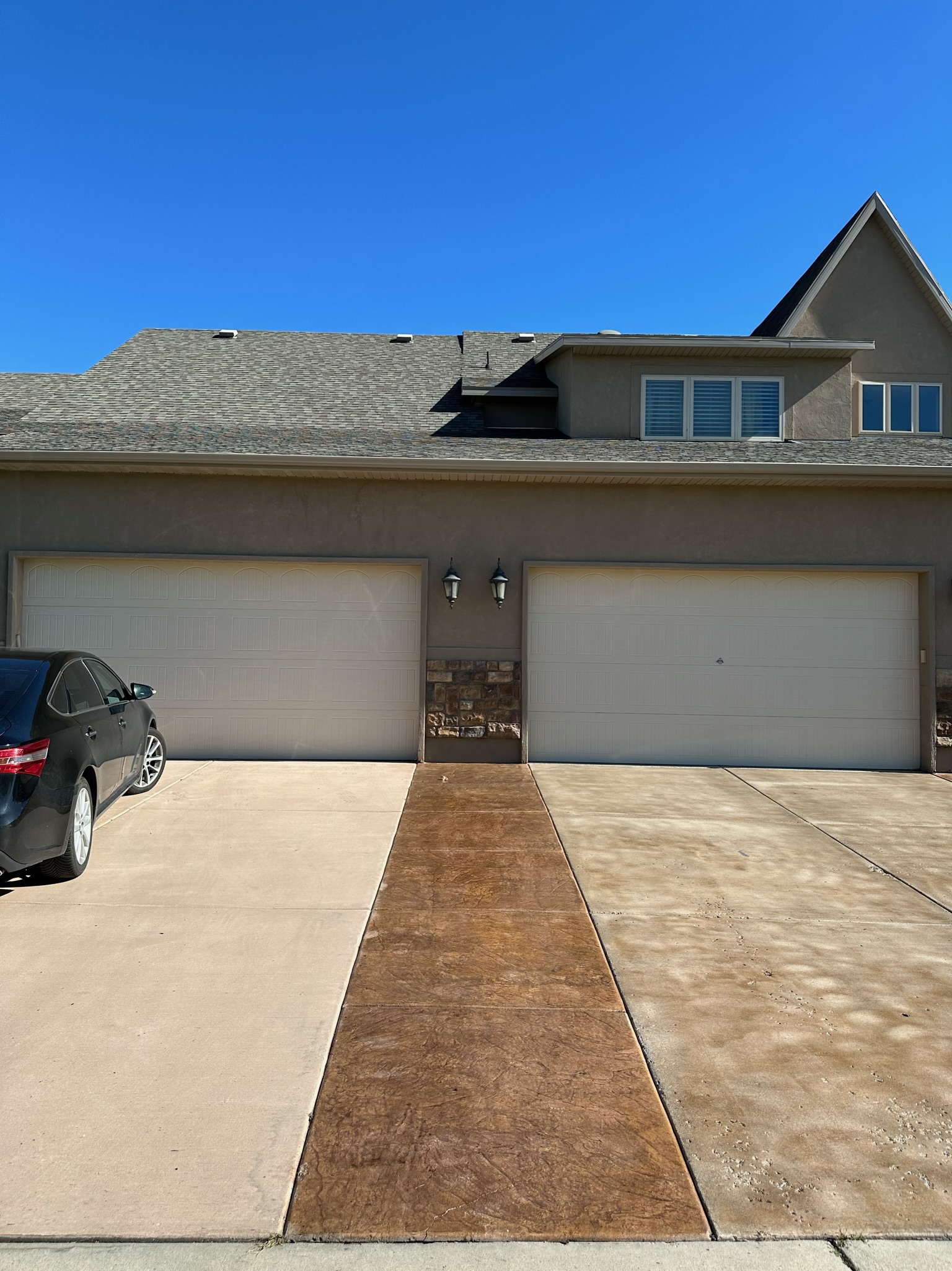 Three car garage driveway with stamped accent coating strip - Sparks Coatings Utah