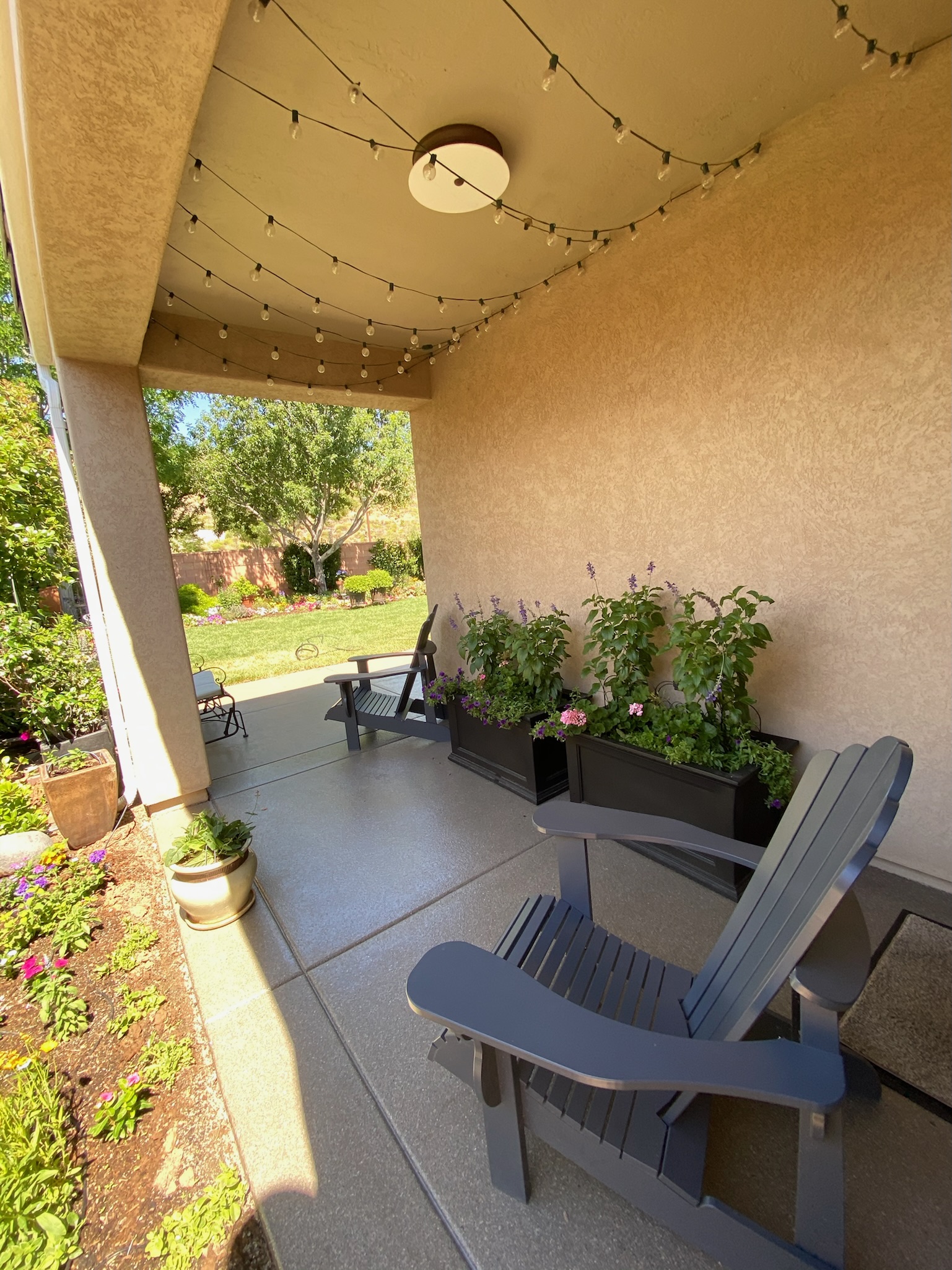 Covered front patio with textured floor coating and outdoor seating