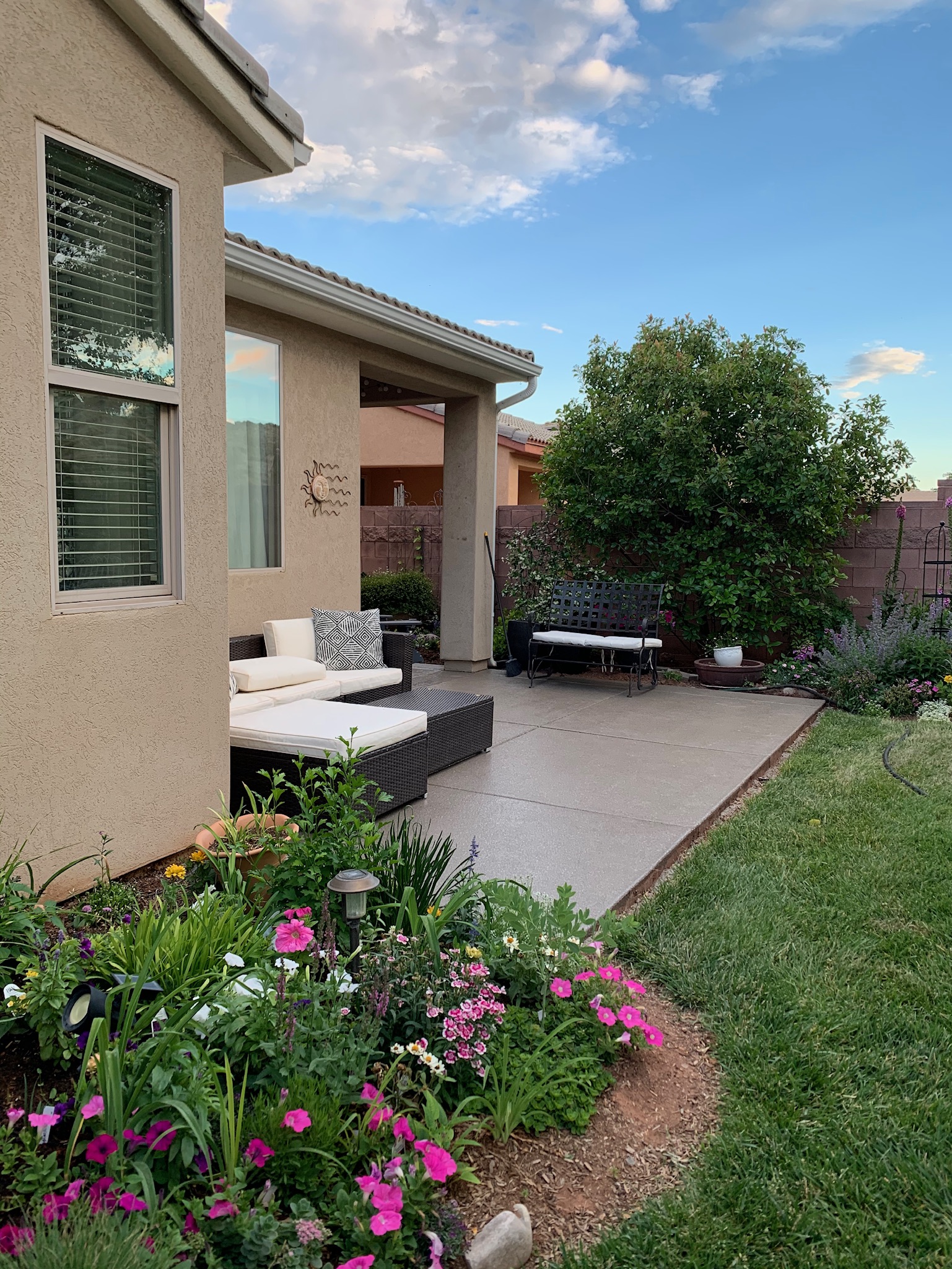 Backyard patio with professional coating surrounded by garden and flowers - Sparks Coatings