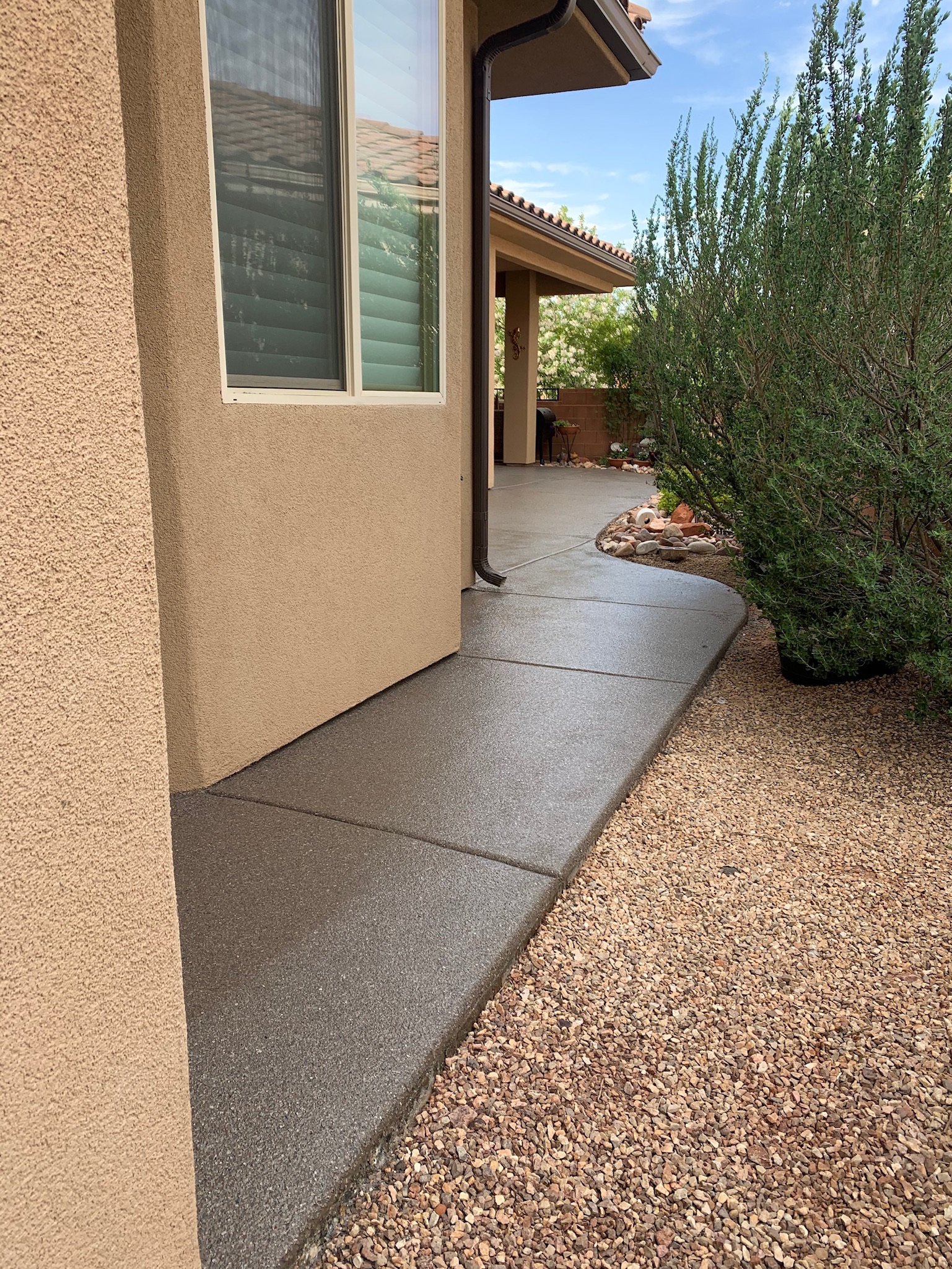 Gray coated side walkway alongside desert landscaping - Sparks Coatings