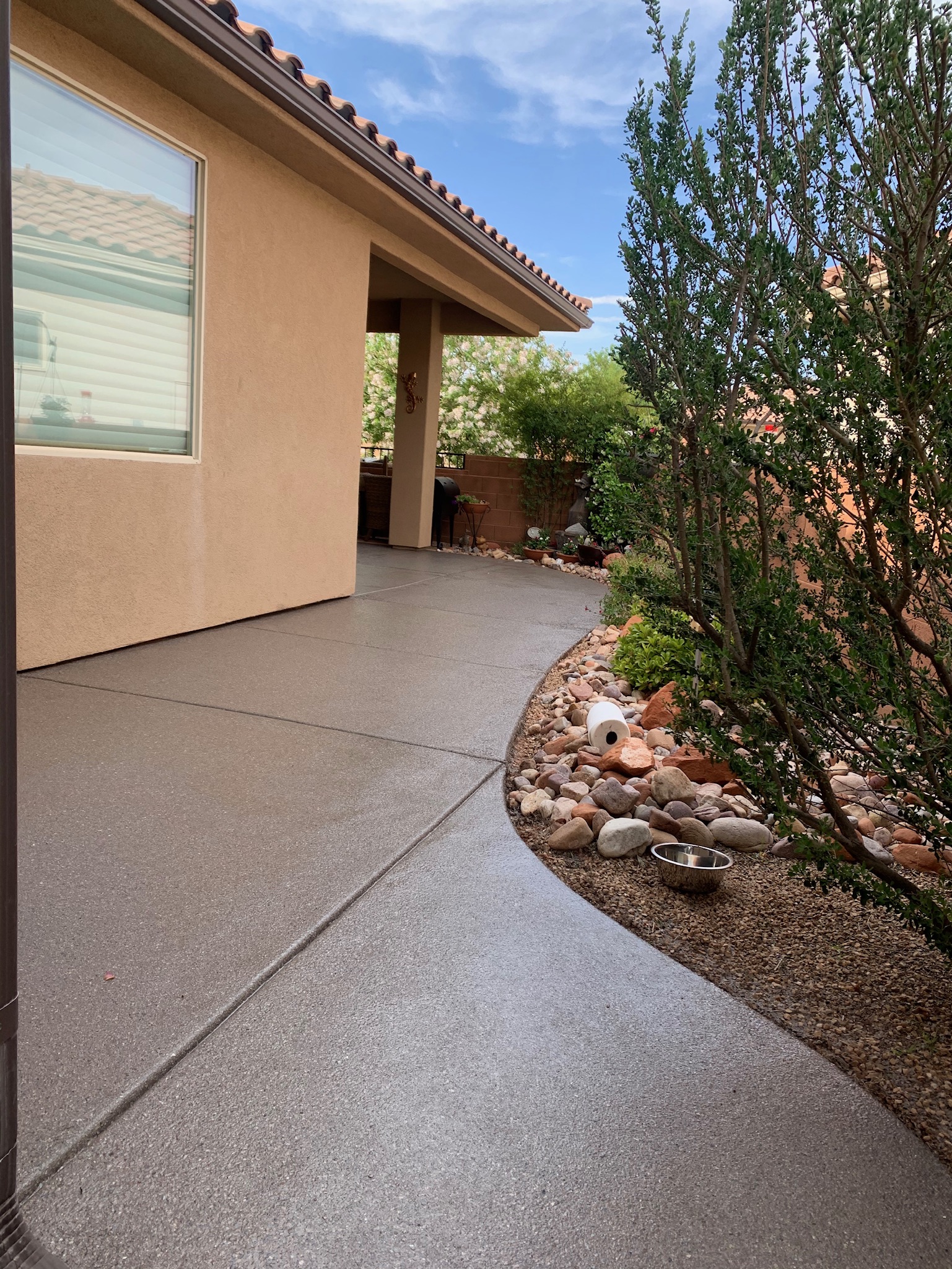 Wide gray coated walkway leading to covered patio with desert plants - Sparks Coatings