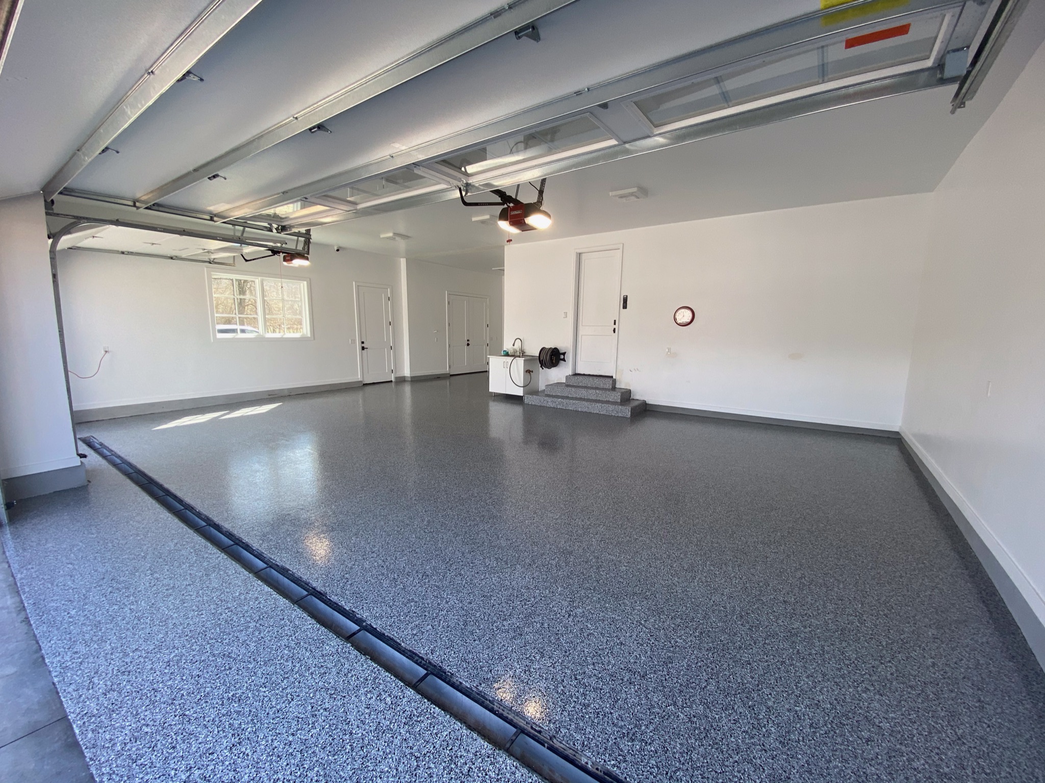 Wide three car garage with uniform gray speckle floor coating