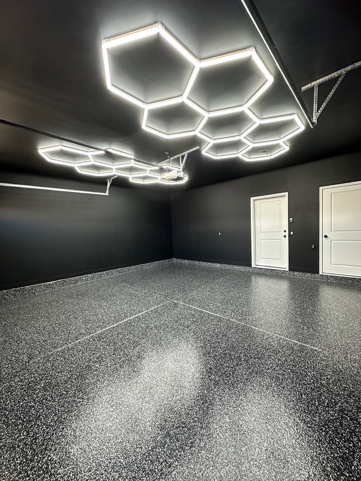 Dark garage with hexagonal LED lights and premium floor coating - Sparks Coatings Utah