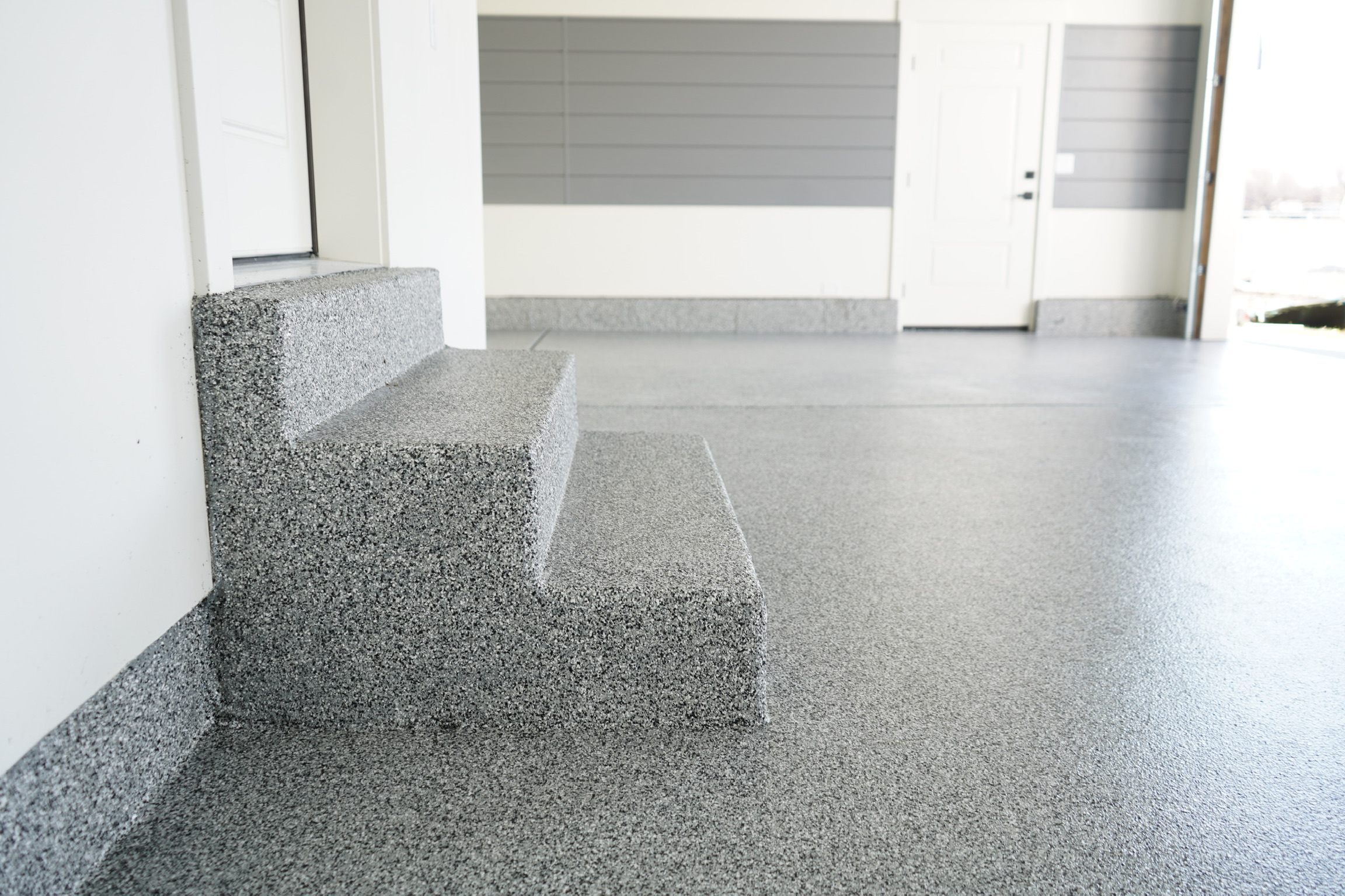 Steps and garage floor covered with full broadcast gray flake coating - Sparks Coatings