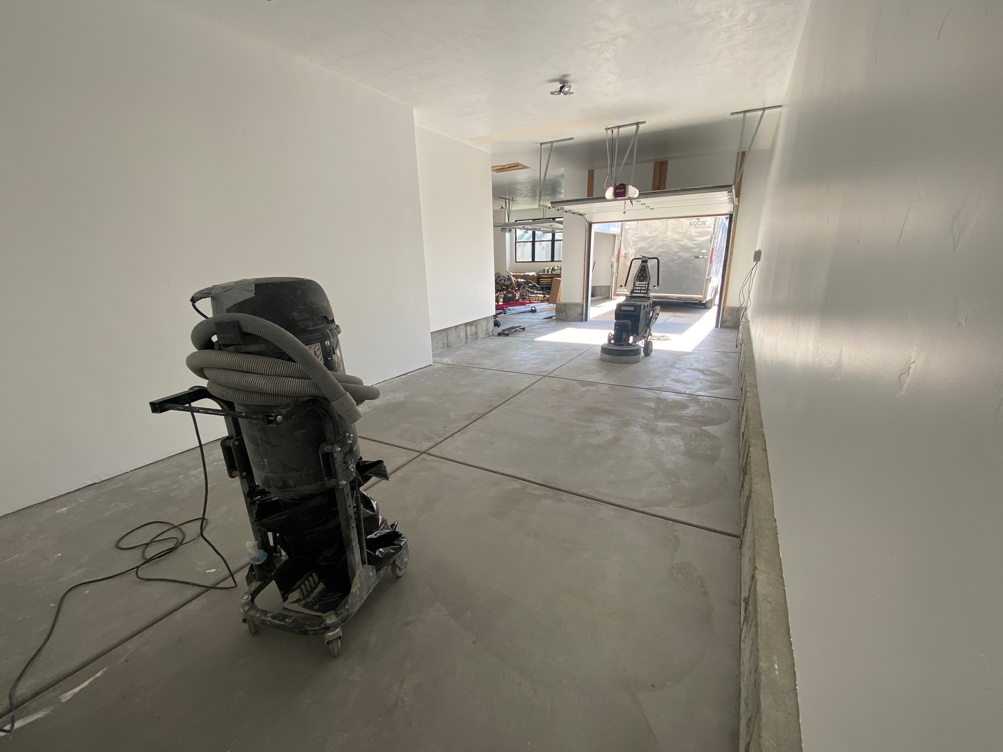 Diamond grinder and vacuum system preparing garage concrete surface - Sparks Coatings Utah